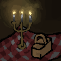 A little three-armed candleholder with three lit candles and a basket over a gingham tablecloth. The scene is dark.
